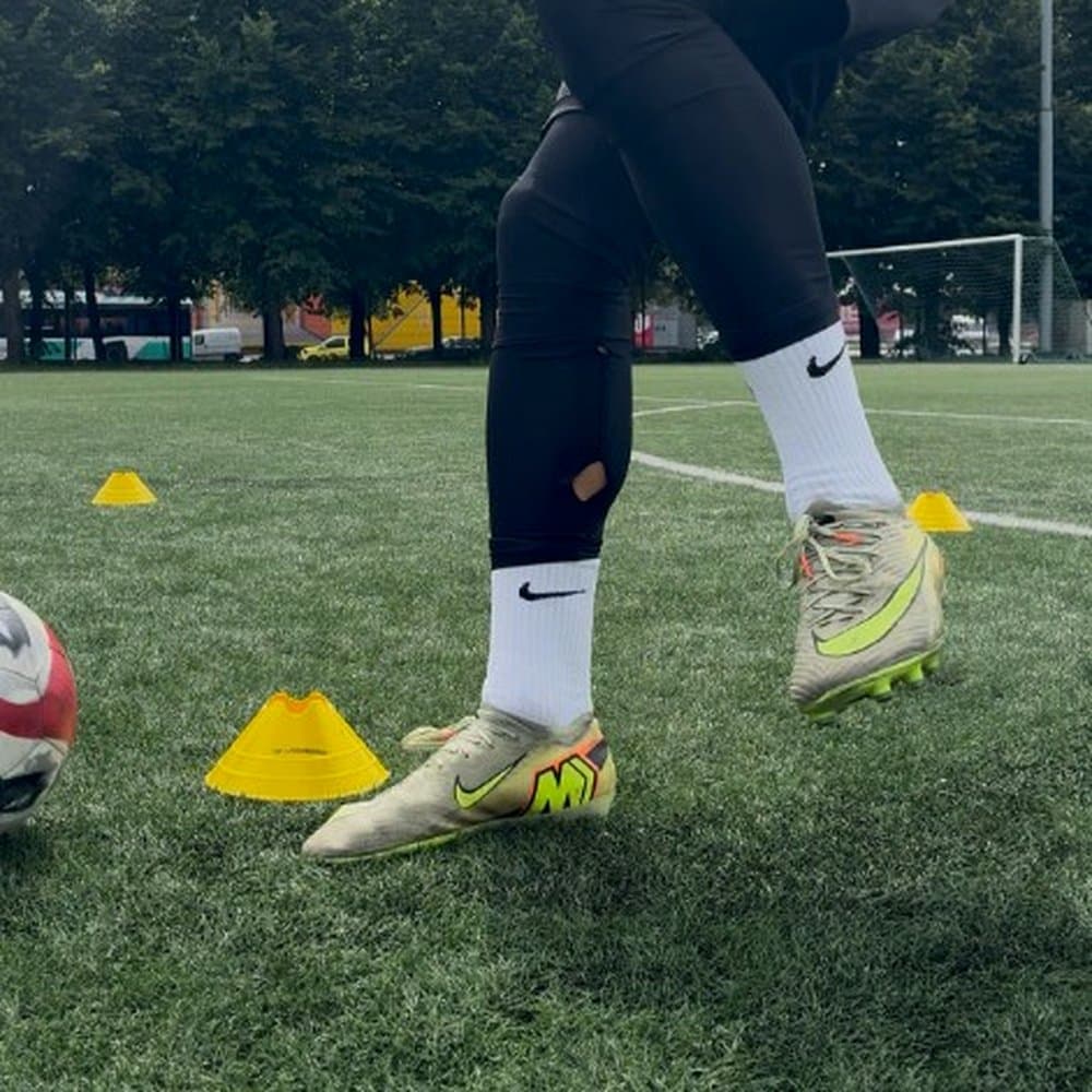 Footwork detail: boots and ball on the pitch